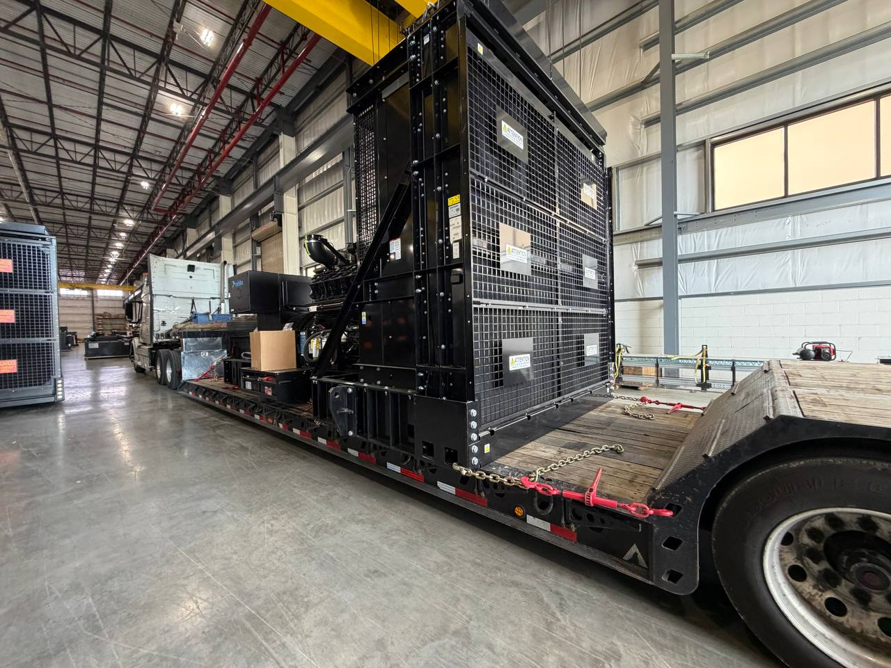 Oversize industrial machinery secured with chains on a flatbed